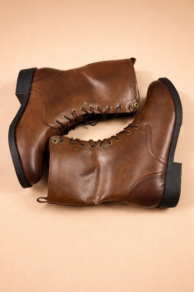 Brown lace-up mid-calf boots arranged overlapping on their sides, highlighting the front lacing, rounded toes, black soles, and heel blocks.