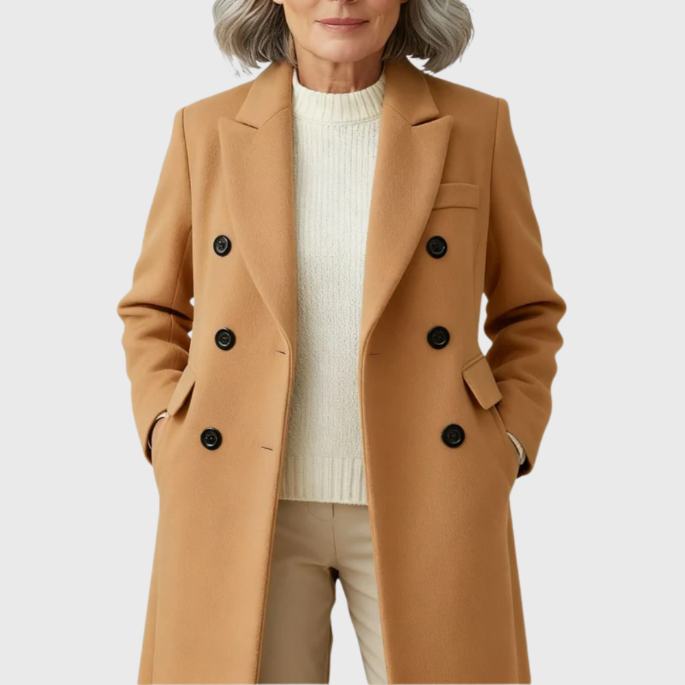 Camel tailored coat worn over a light sweater, highlighting its notched lapels, double-breasted buttons, chest detail, and flap pockets.
