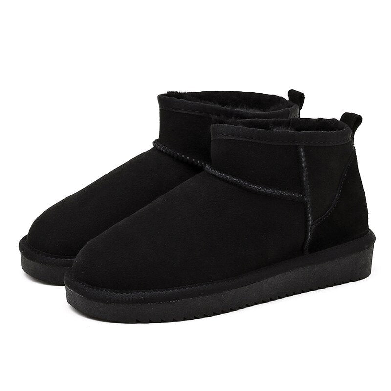 Pair of black low ankle snow boots with plush lining, stitched panel details, pull tabs, and thick textured soles.