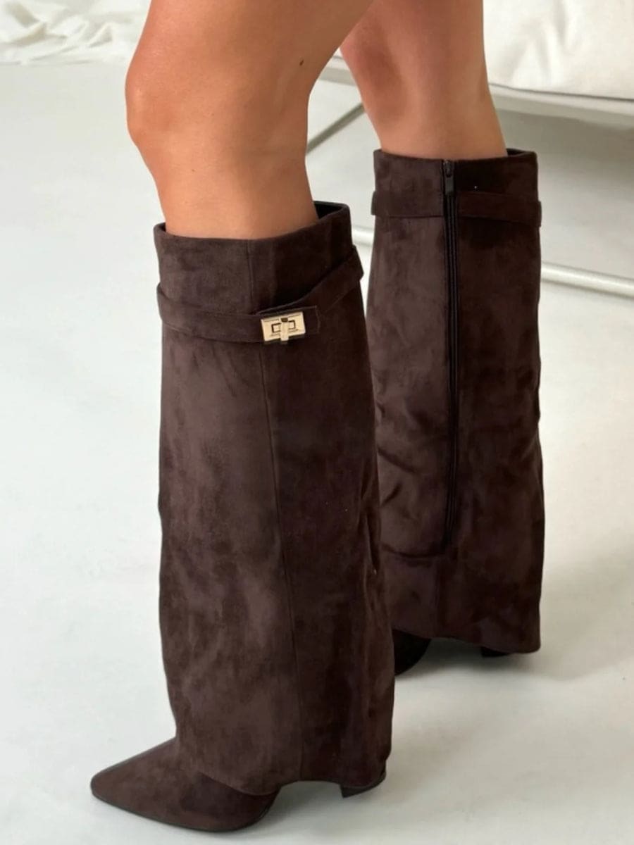 Rear three-quarter view of dark brown knee-high boots showing the back zipper, fold-over cuffs, pointed toes, and low heels.