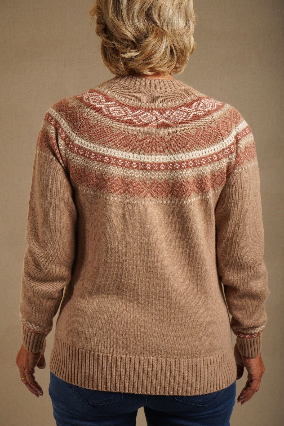 Woman standing outdoors wearing a long-sleeved button-front knit cardigan with a patterned Fair Isle yoke, ribbed crew neck, cuffs and hem, with jeans._3