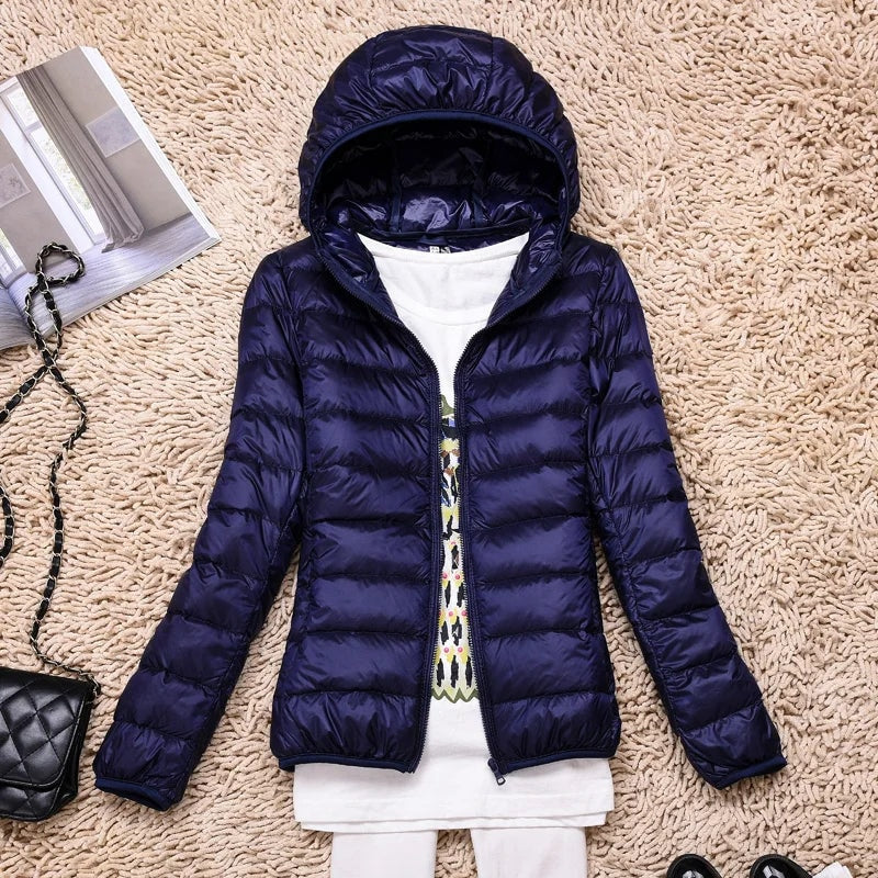Dark navy hooded puffer jacket shown open and laid flat with its quilted construction visible.