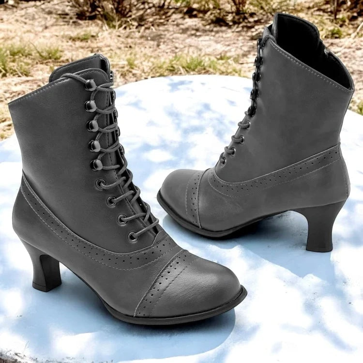 Black Victorian-style boots displayed from a slightly closer angle, highlighting the front lacing, perforated toe panels, and raised heels.