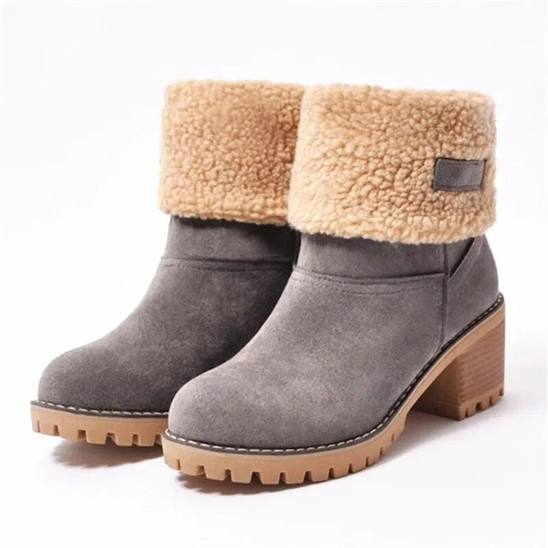 Gray ankle boots shown from the front and side, highlighting the wide textured cuffs, rounded toe shape, wooden-look block heels, and lugged soles.