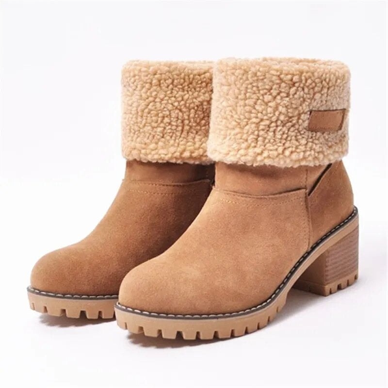Tan ankle boots in a three-quarter view, showing their fold-over textured cuffs, side tab detail, rounded toes, stacked heels, and thick treaded soles.