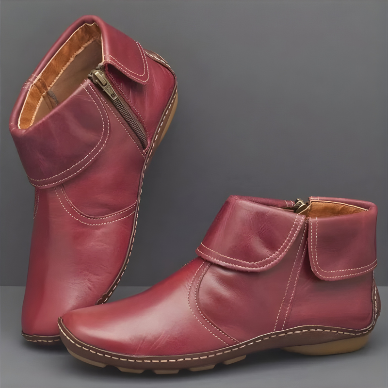 Burgundy ankle boots with curved foldover collars, contrast stitching, side zips, low heels, and textured soles, shown from front and side angles.