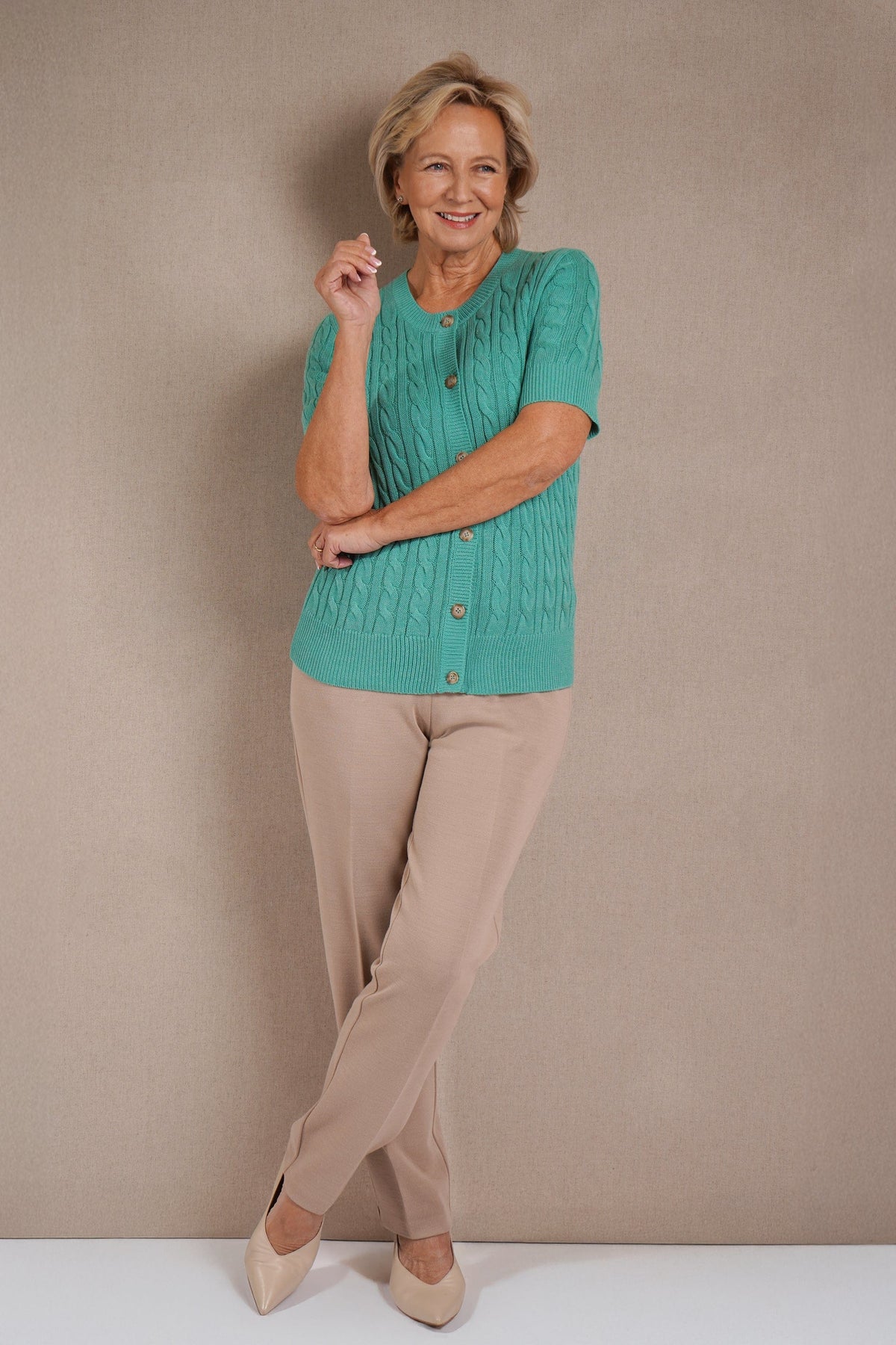 Short sleeve cable knit cardigan with round neckline, ribbed cuffs and hem, and a full row of front buttons._1