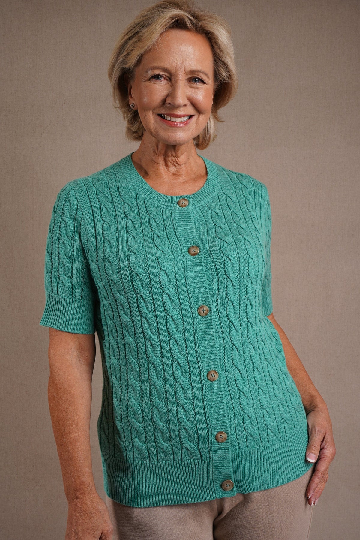 Short sleeve cable knit cardigan with round neckline, ribbed cuffs and hem, and a full row of front buttons._3