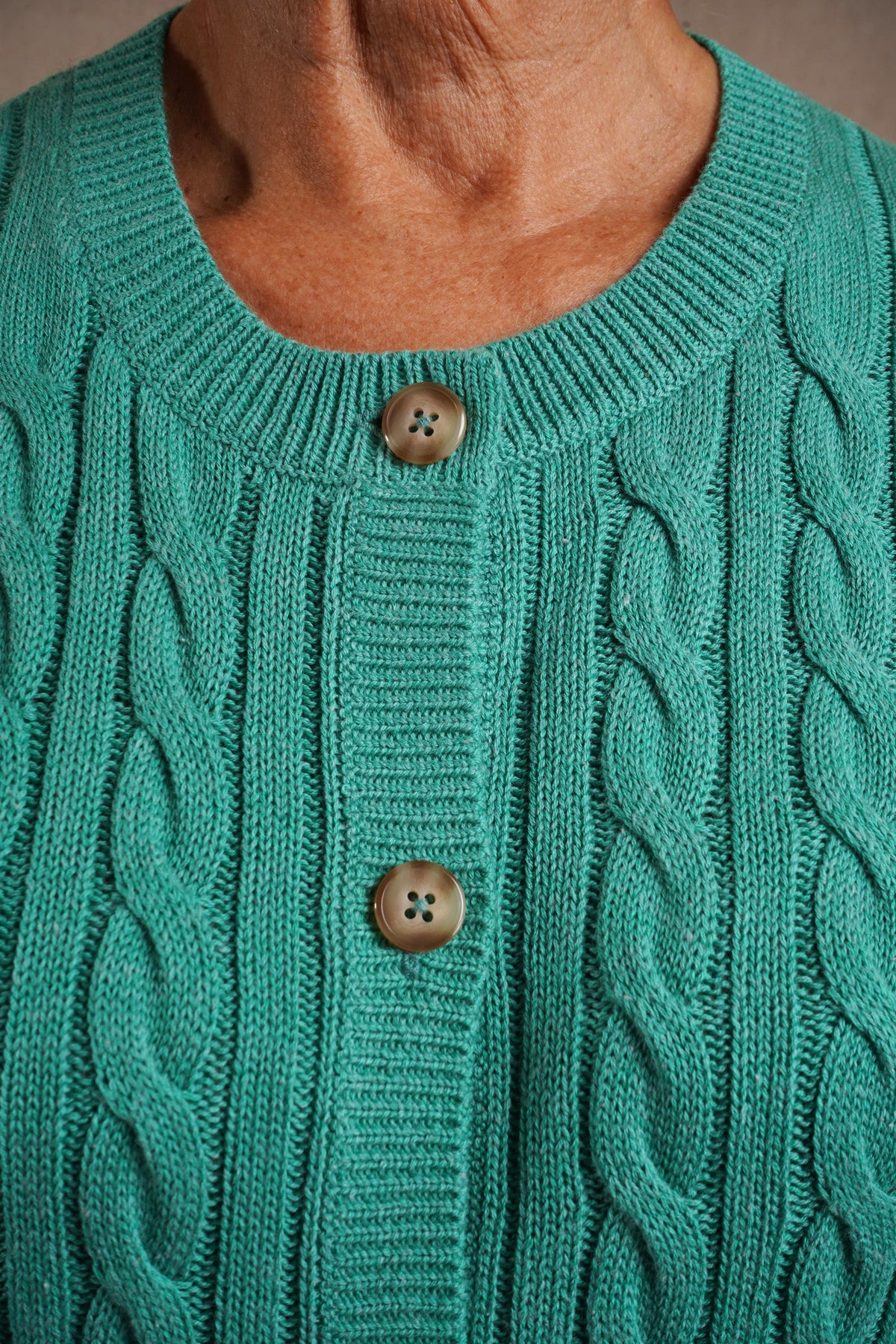 Short sleeve cable knit cardigan with round neckline, ribbed cuffs and hem, and a full row of front buttons._9