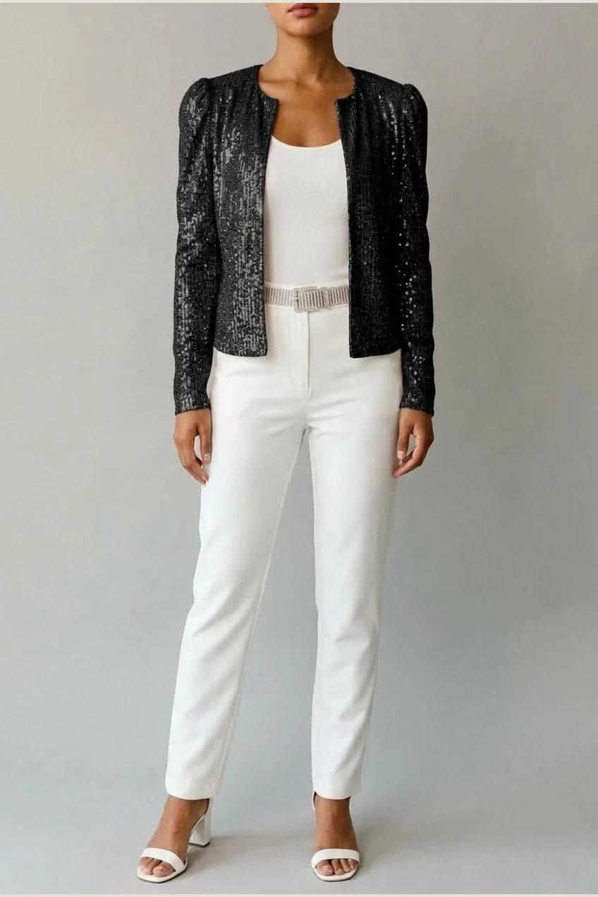 Model wearing an open-front cropped sequin jacket with long sleeves and structured shoulders over a tank top and tailored trousers._1