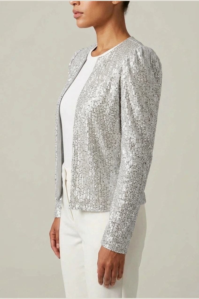 Model wearing an open-front cropped sequin jacket with long sleeves and structured shoulders over a tank top and tailored trousers._10