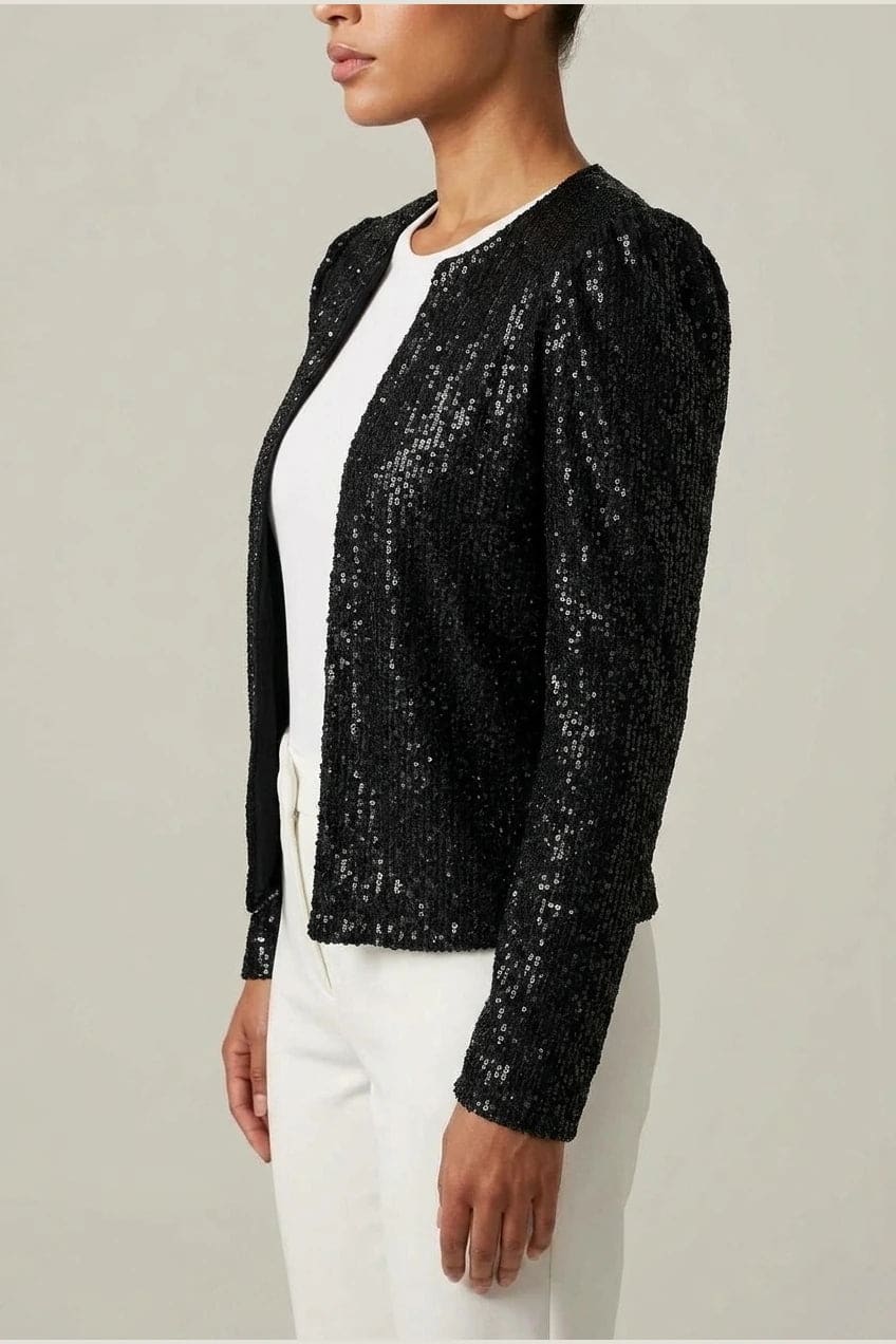 Model wearing an open-front cropped sequin jacket with long sleeves and structured shoulders over a tank top and tailored trousers._4