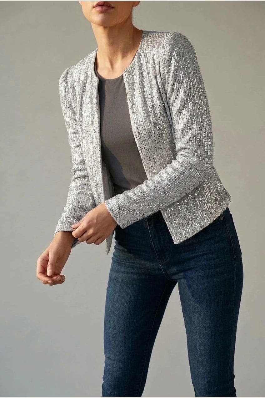 Model wearing an open-front cropped sequin jacket with long sleeves and structured shoulders over a tank top and tailored trousers._8