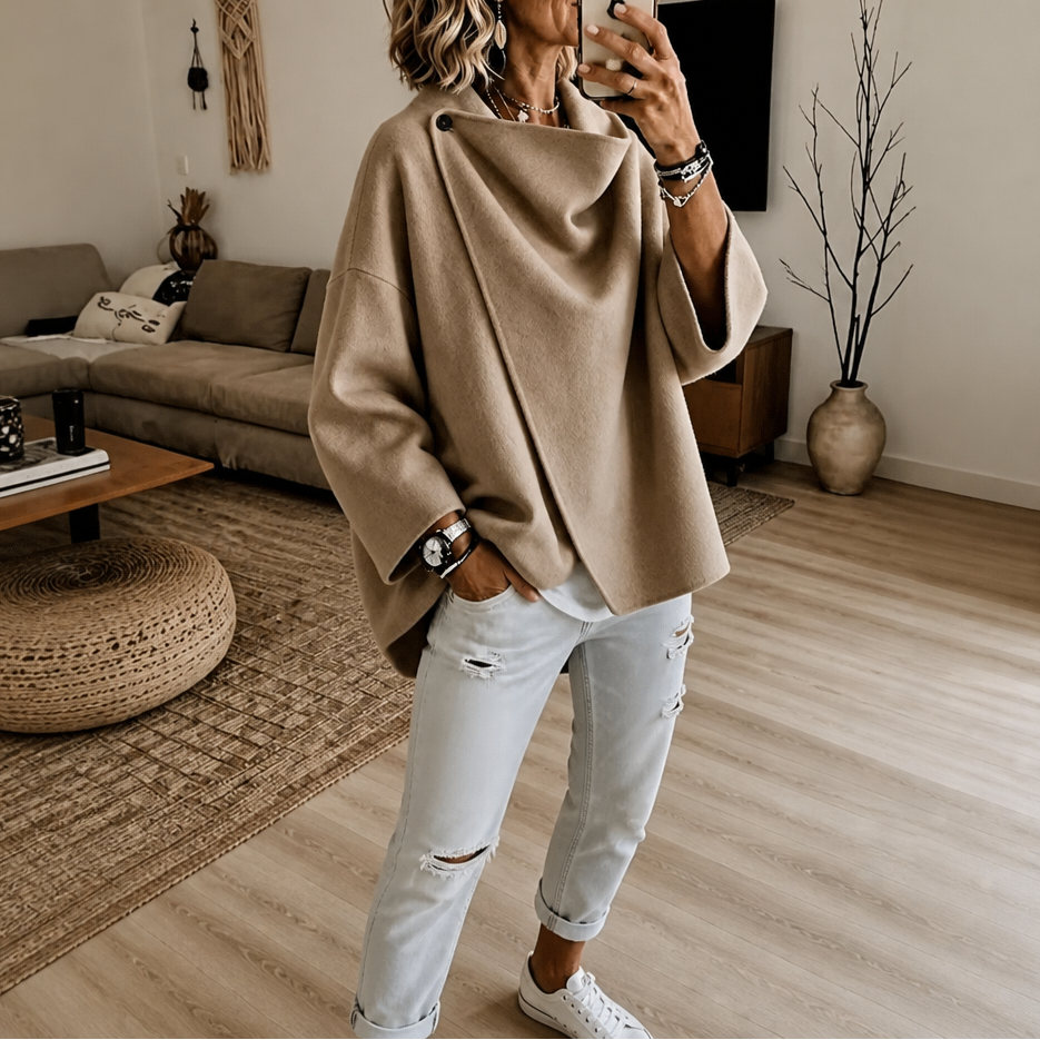 Mirror view of the asymmetric cape jacket in tan, highlighting the overlapping front and button collar detail.