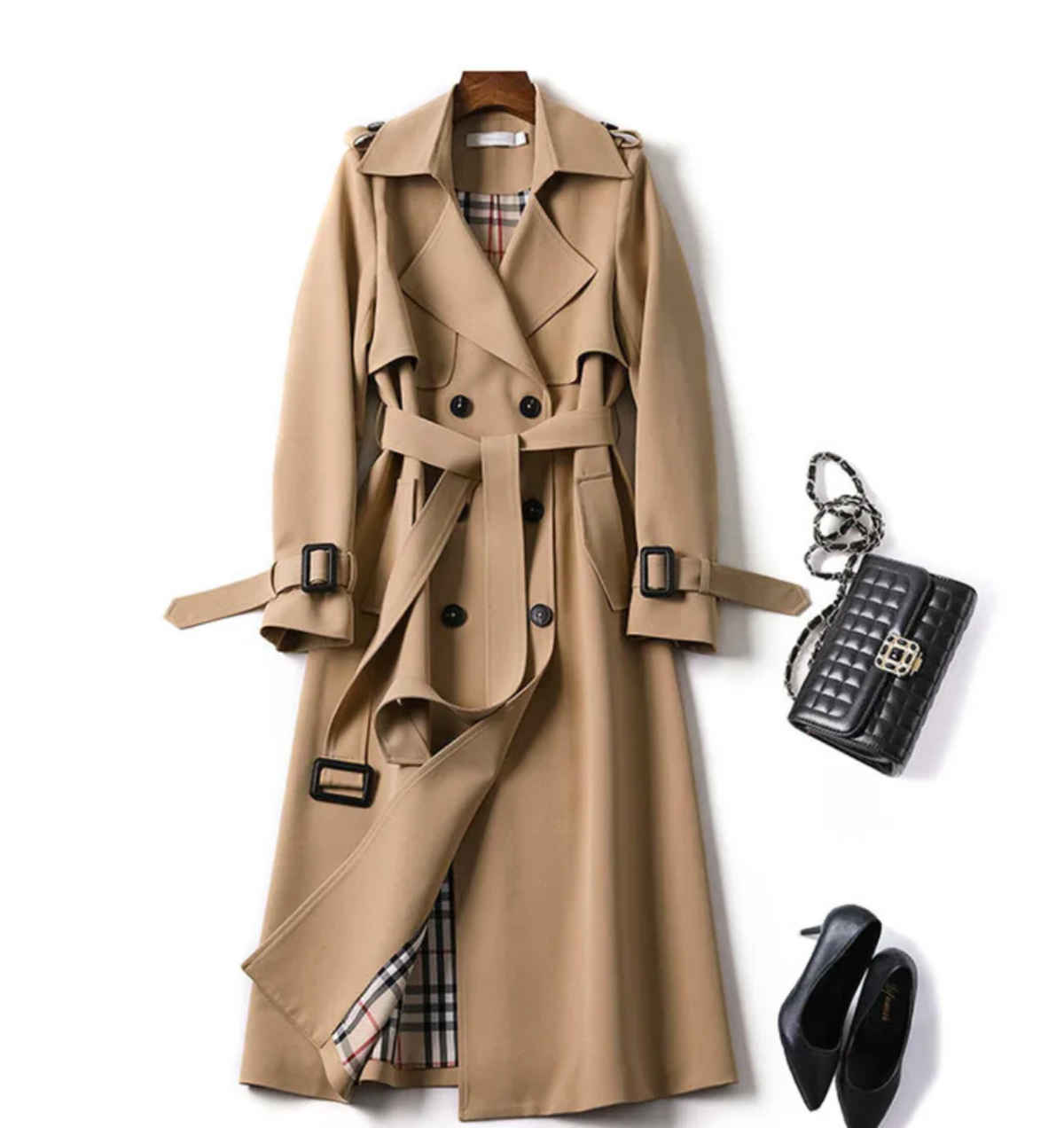 Beige long double-breasted trench coat styled with a tied waist belt, buckled sleeve straps, and a partially open front revealing a checked lining.