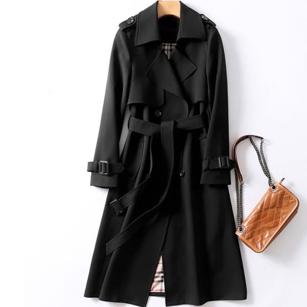 Black long trench coat displayed with its double-breasted front fastened, belted waist, shoulder tabs, and buckled sleeve straps.