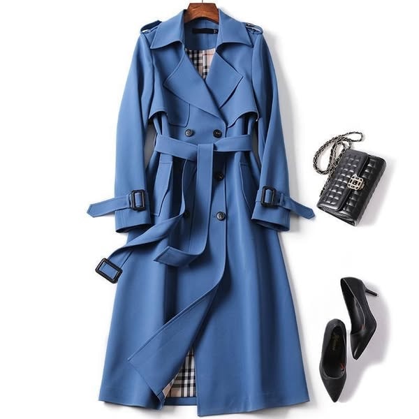 Blue belted double-breasted trench coat shown with the front partly open, long silhouette, and adjustable sleeve straps extending at the cuffs.