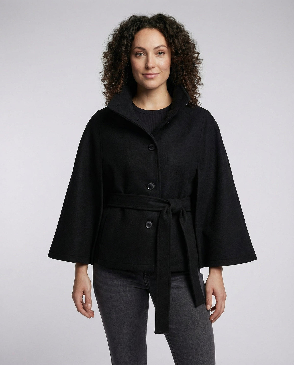 Model wearing a black belted wrap jacket with a stand collar, button front, and wide three-quarter sleeves.