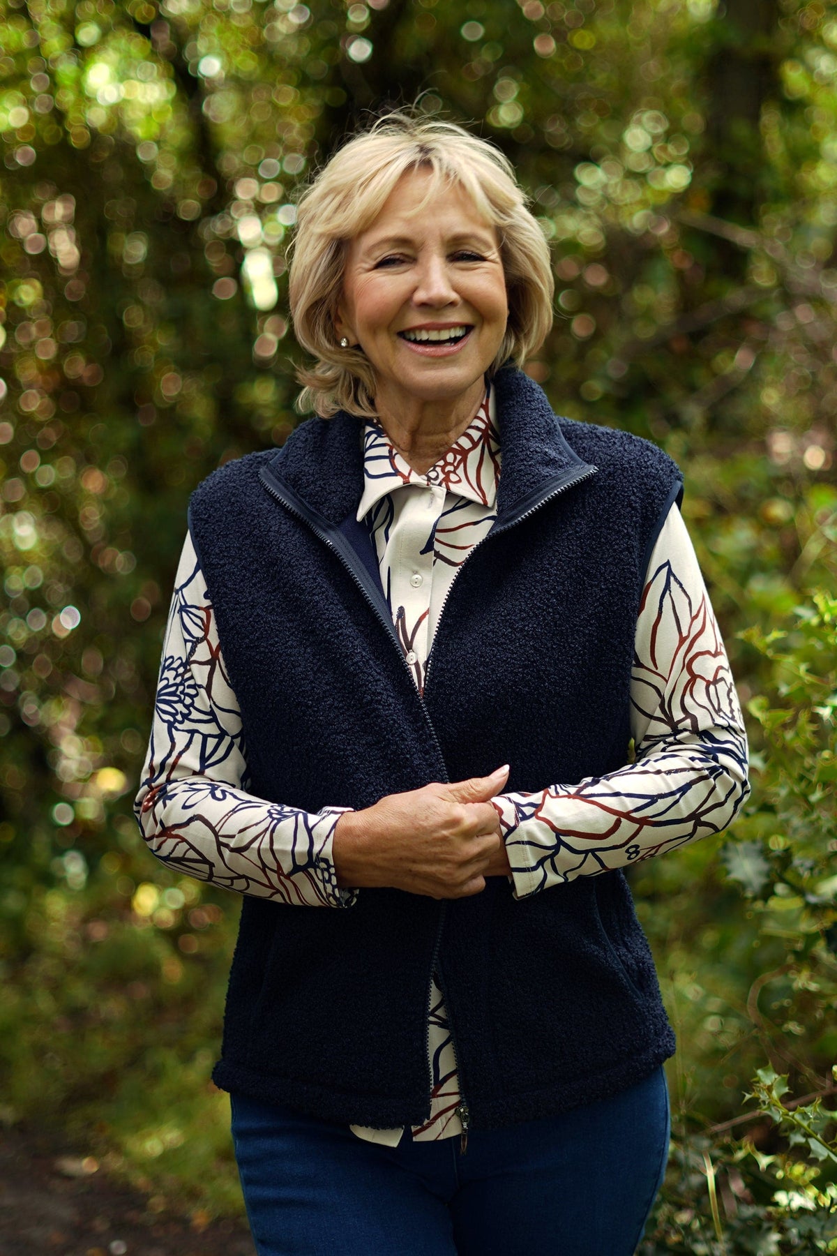 Woman wearing a sleeveless textured zip-front gilet with a stand collar and side pockets over a long-sleeved top and trousers._1