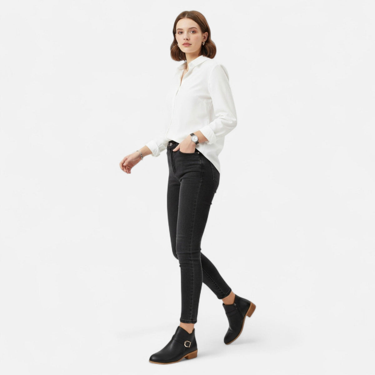 Model wearing black buckle strap ankle boots with black skinny jeans, showing the boots styled in a full outfit.