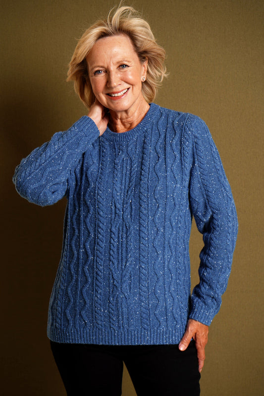 Woman wearing a flecked cable knit crew neck jumper with long sleeves and ribbed trims, with dark trousers._0