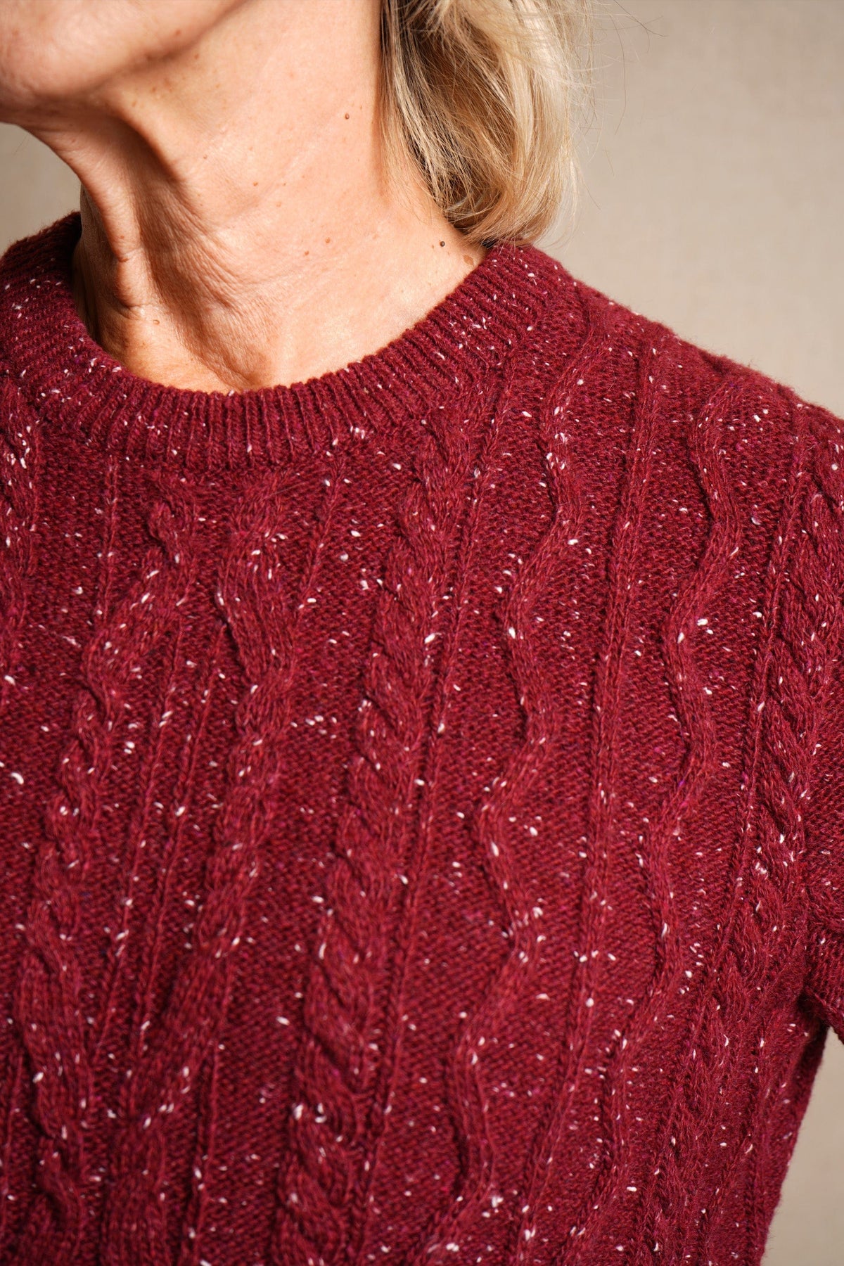 Woman wearing a flecked cable knit crew neck jumper with long sleeves and ribbed trims, with dark trousers._5