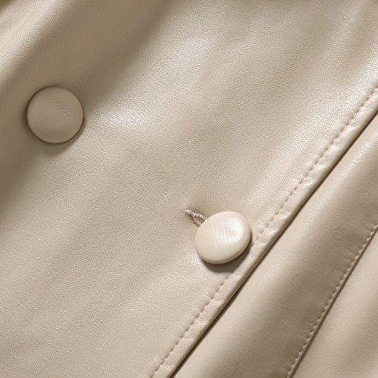A long double-breasted trench coat with wide lapels and a tied waist belt displayed on a hanger._11