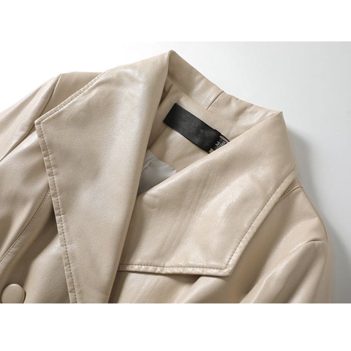 A long double-breasted trench coat with wide lapels and a tied waist belt displayed on a hanger._7