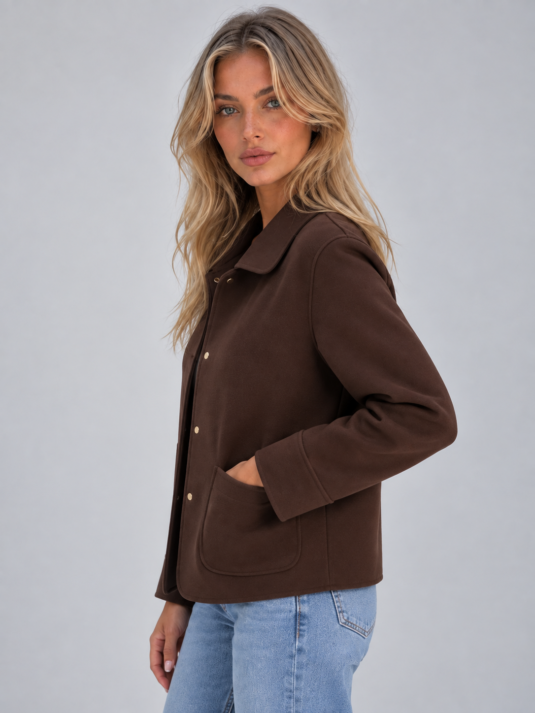 Side view of the brown collared jacket highlighting the patch pocket, button fastening, and relaxed fit.