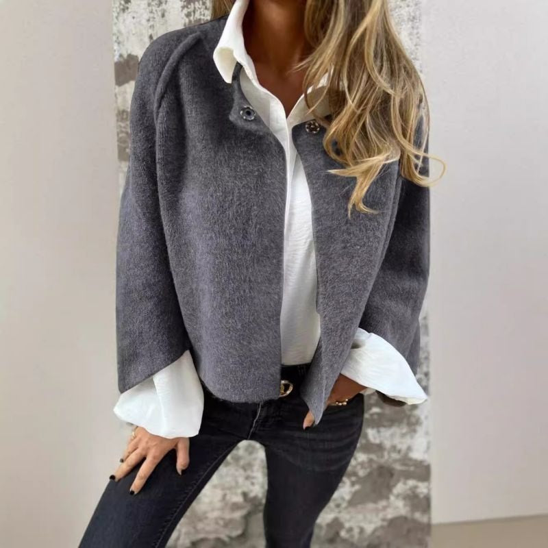Charcoal collarless jacket layered over a white collared shirt, shown with its front open.