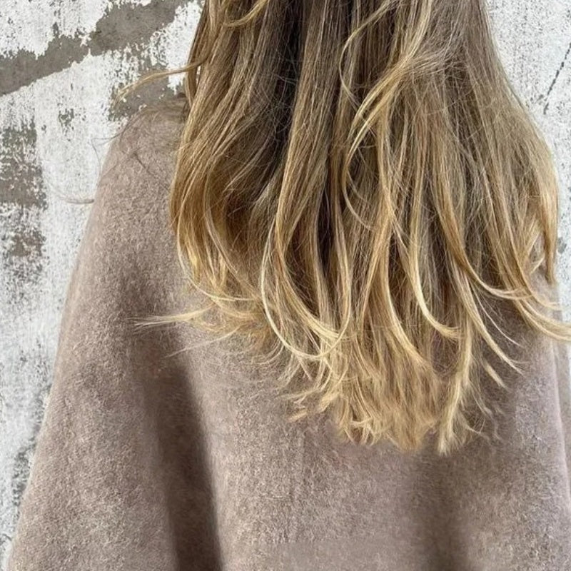 Back view of the taupe jacket, showing its relaxed shape and long sleeves.