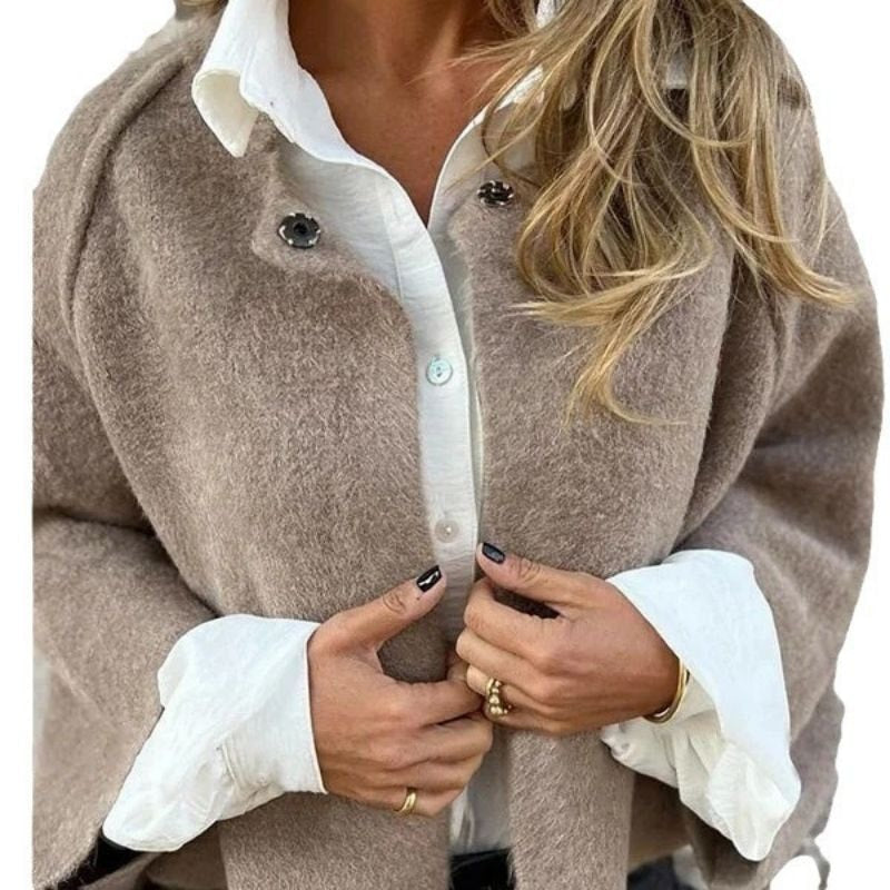 Close-up of the taupe jacket being fastened over a white collared shirt, highlighting its collarless neckline and front buttons.