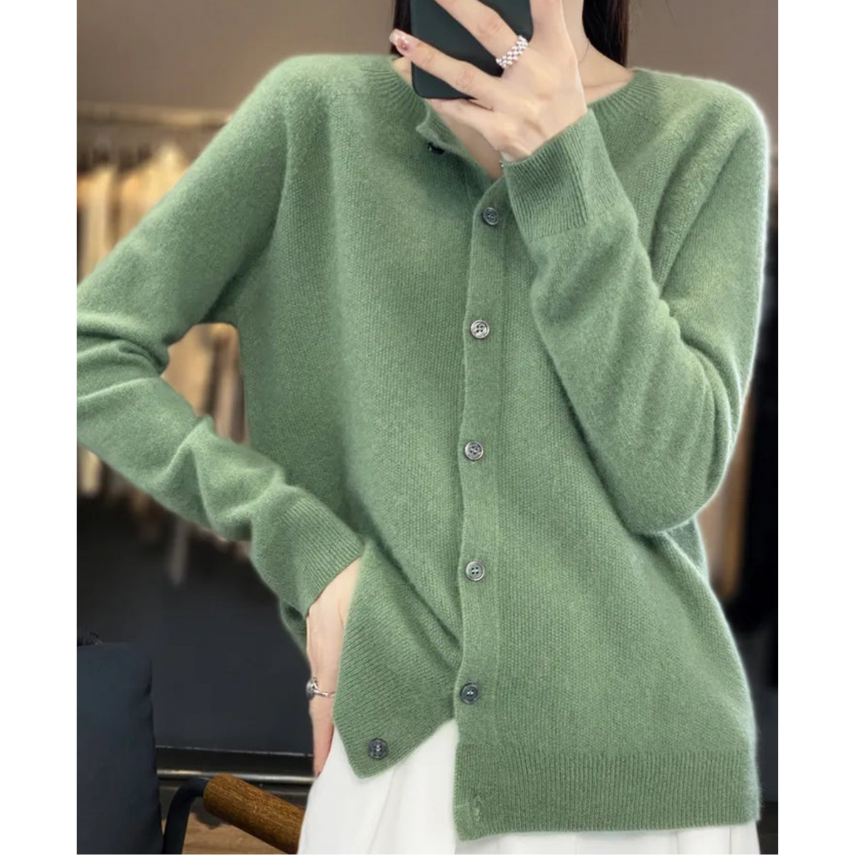 Sage green button-front cardigan shown in a side pose with one hand at the hip