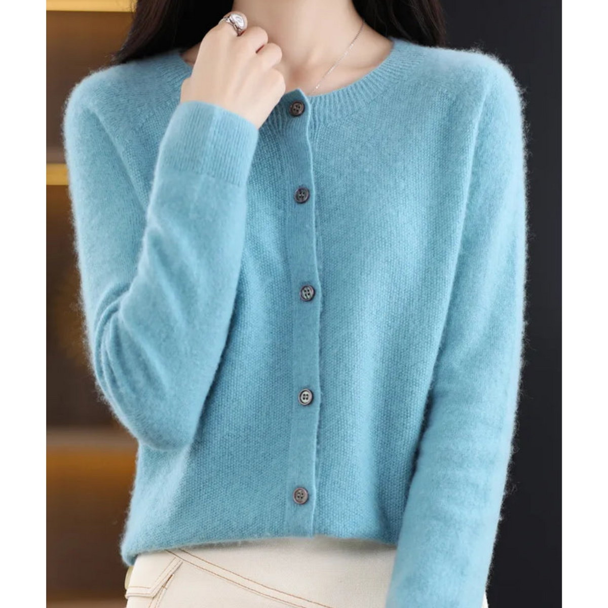 Light blue crew neck cardigan paired with cream trousers