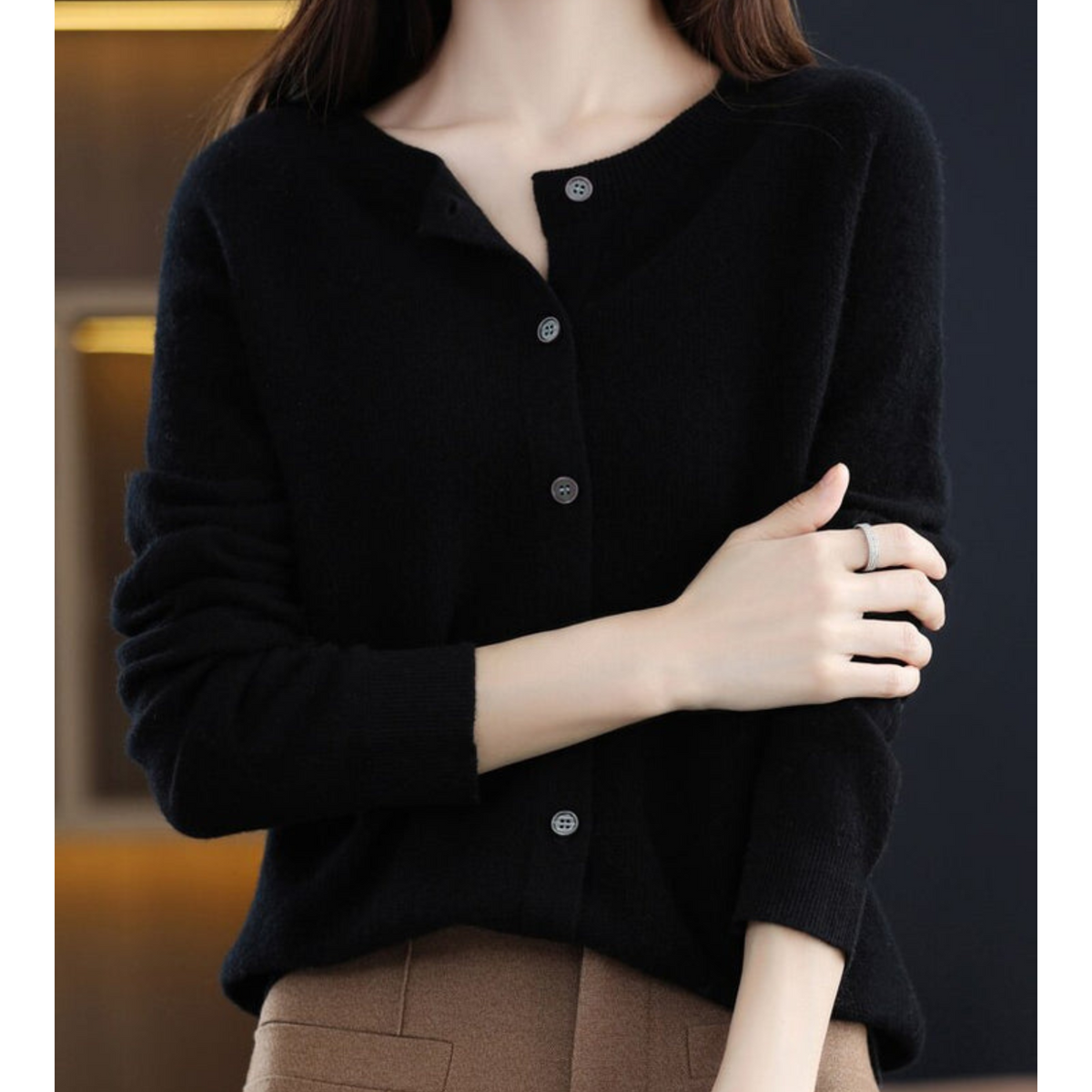 Black cardigan with a partially open neckline and sleeves pushed up