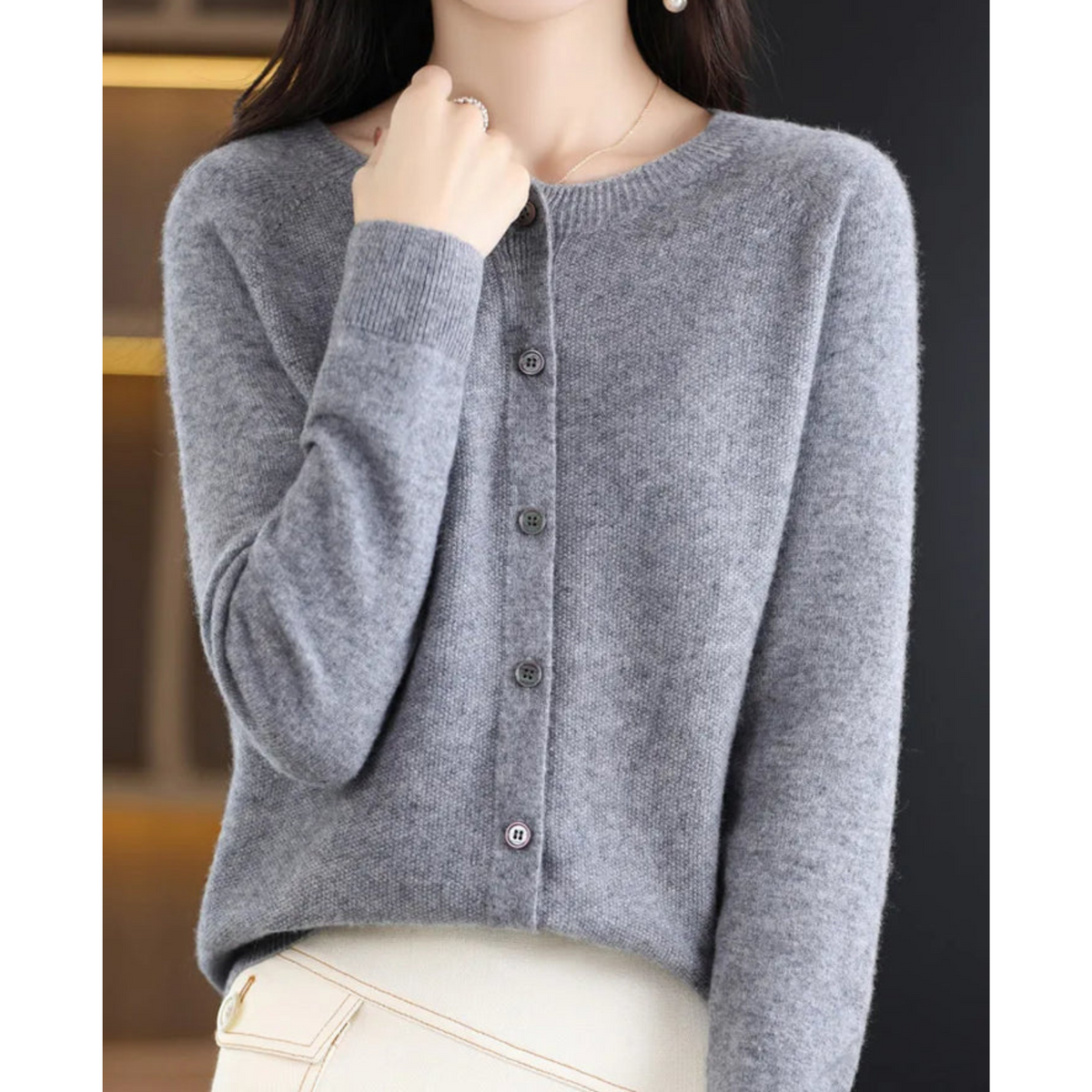 Gray crew neck cardigan styled over cream trousers