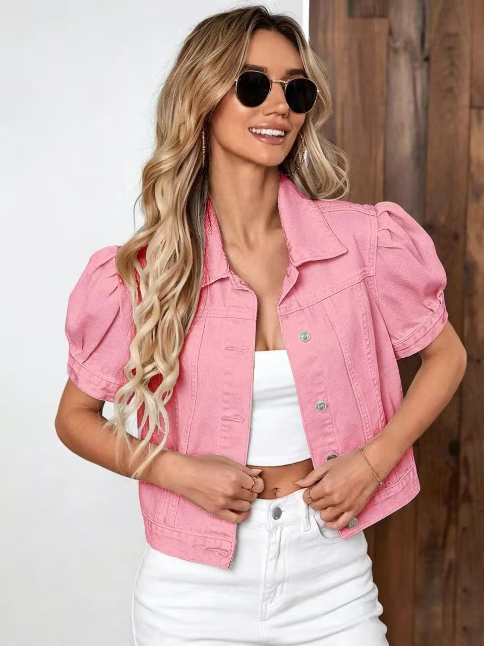 Pink cropped jacket with dramatic puff short sleeves, a point collar, chest pockets, and silver-toned front buttons.