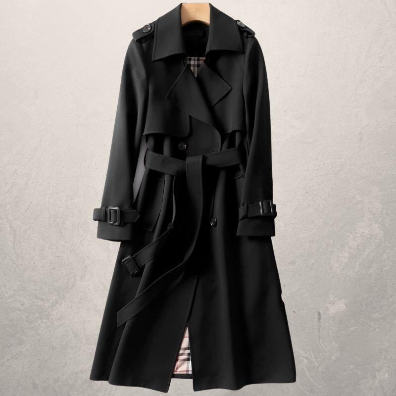 Black double-breasted trench coat on a hanger featuring a waist belt, shoulder tabs, and buckled cuff details.