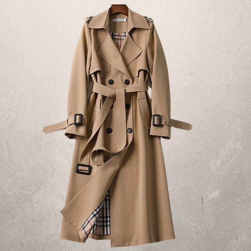 Tan double-breasted trench coat with a tied waist belt, extended cuff straps, and checked lining visible through the open front.