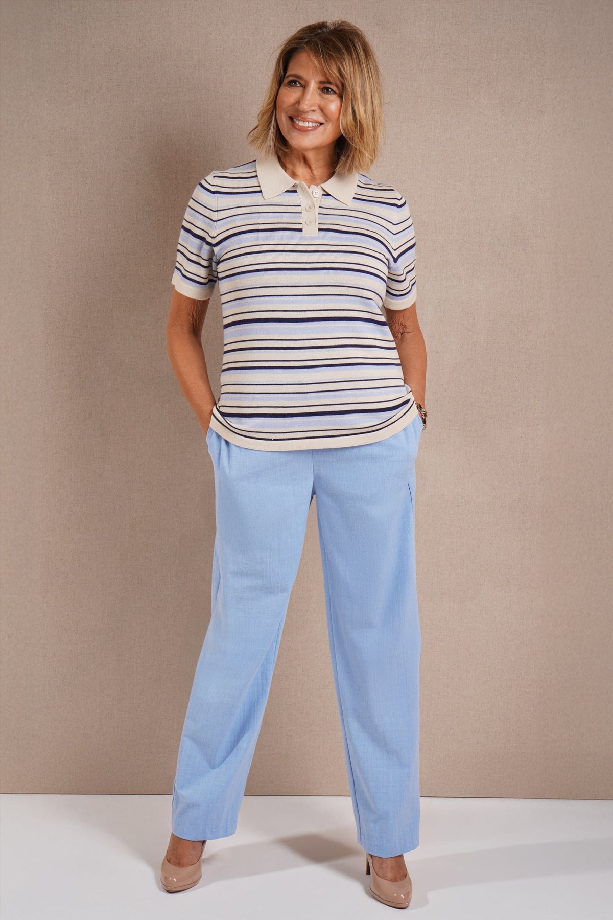 Woman wearing a short sleeve striped knit polo top with a flat collar and three button placket._2