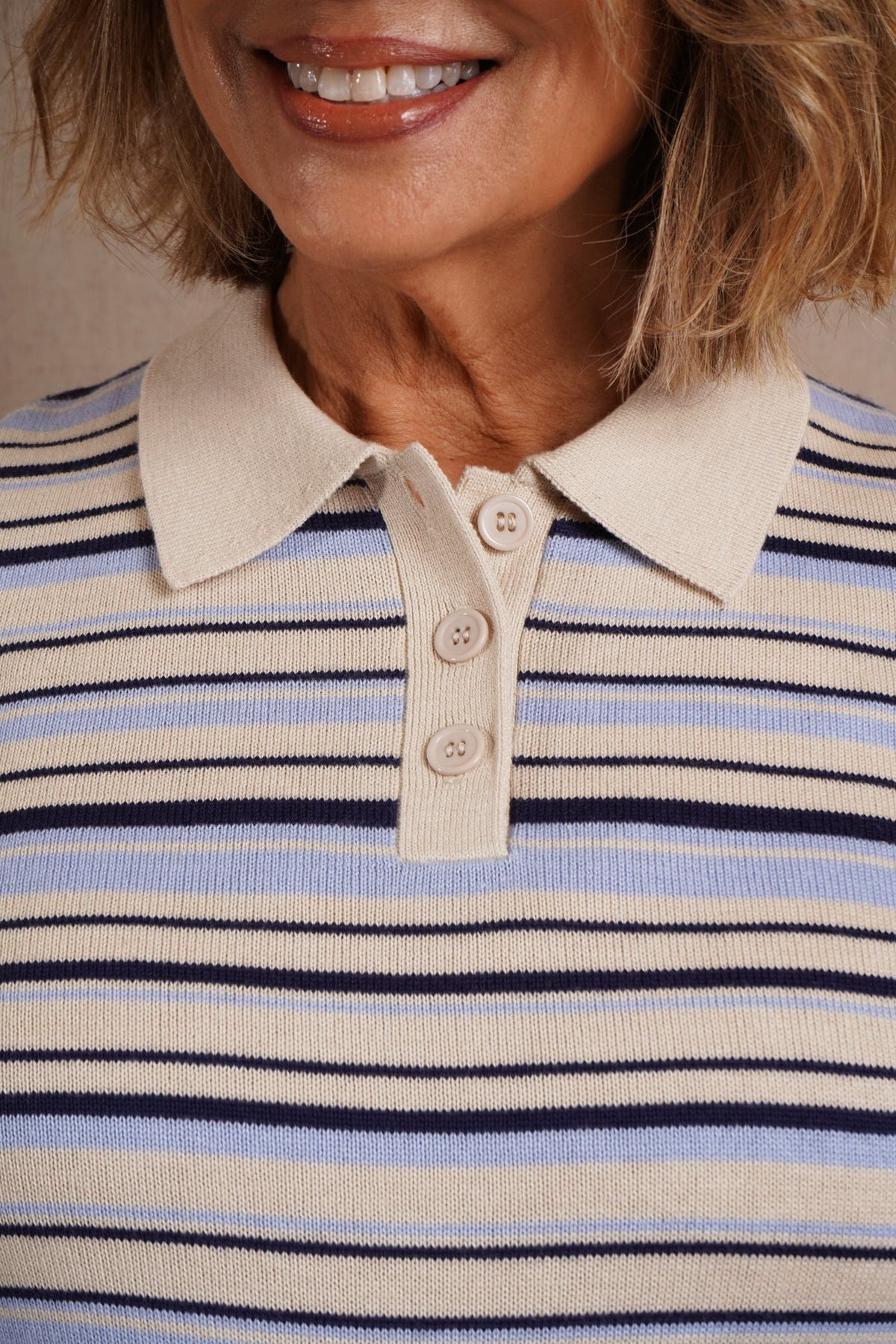 Woman wearing a short sleeve striped knit polo top with a flat collar and three button placket._4