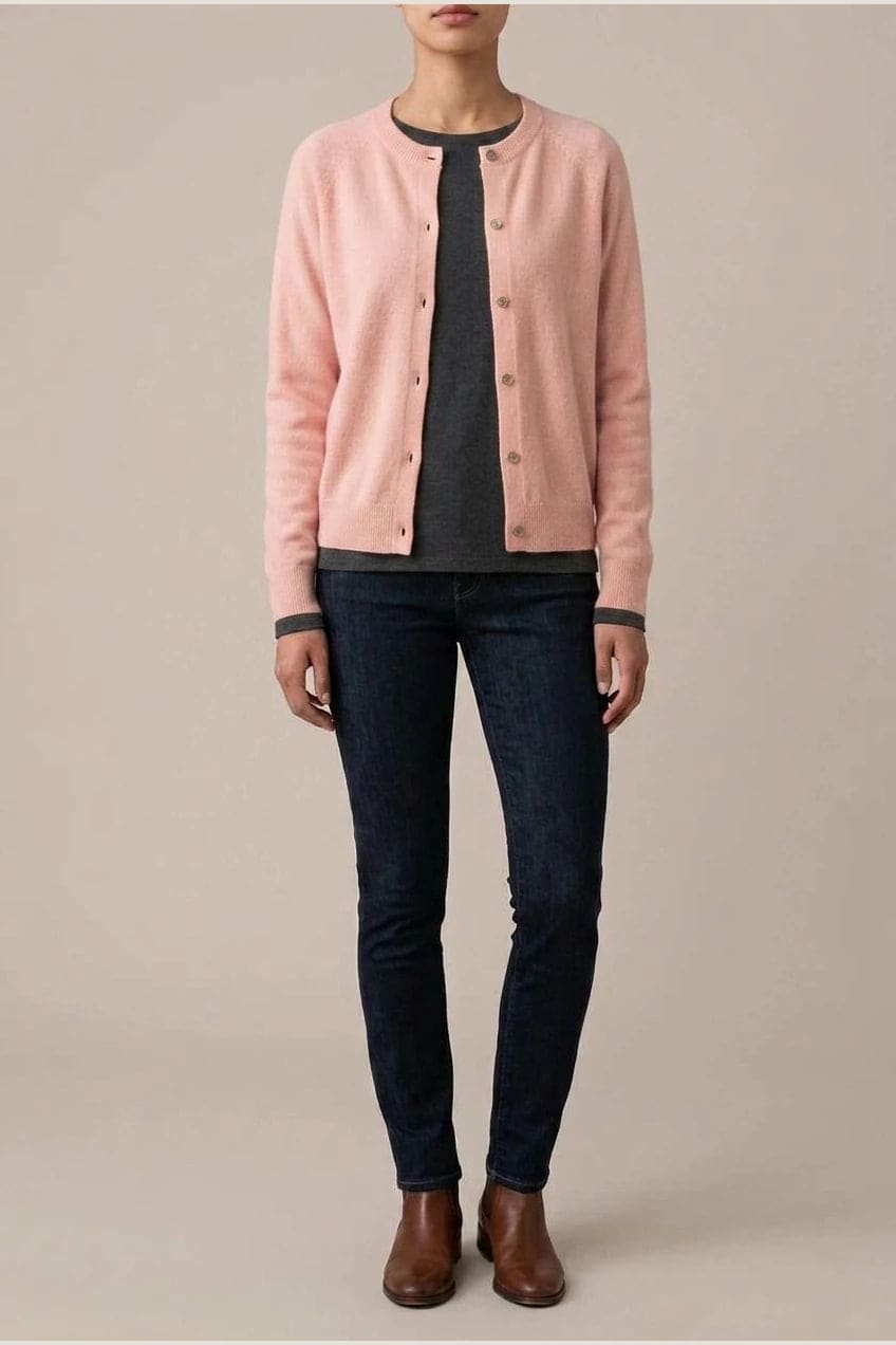 Woman wearing a long sleeve round neck button front cardigan over a grey top with dark slim jeans and ankle boots._1