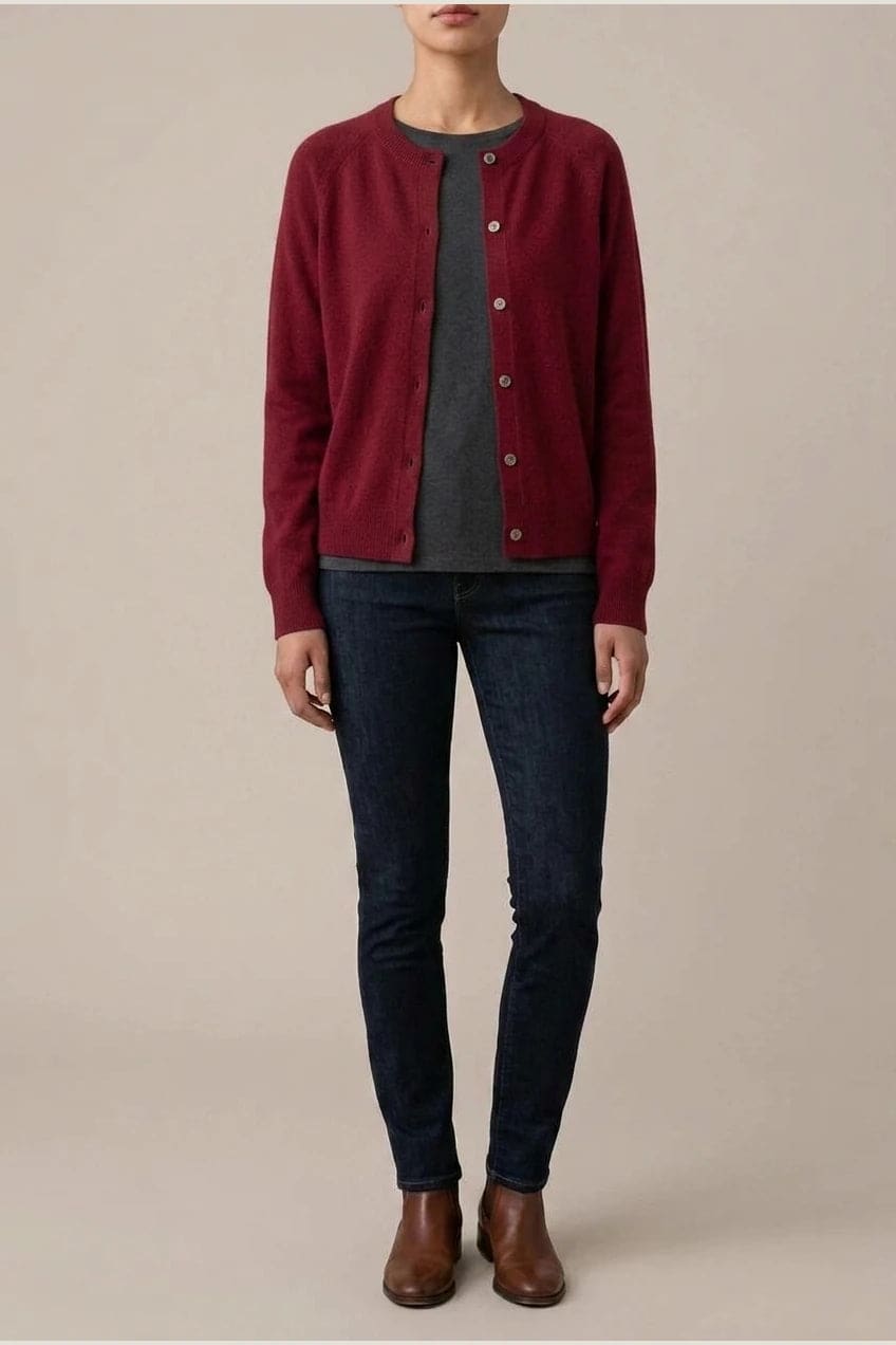 Woman wearing a long sleeve round neck button front cardigan over a grey top with dark slim jeans and ankle boots._19