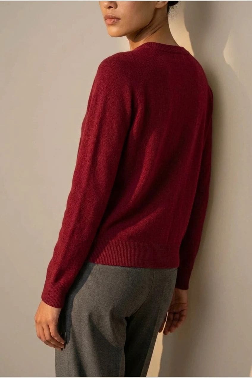 Woman wearing a long sleeve round neck button front cardigan over a grey top with dark slim jeans and ankle boots._21