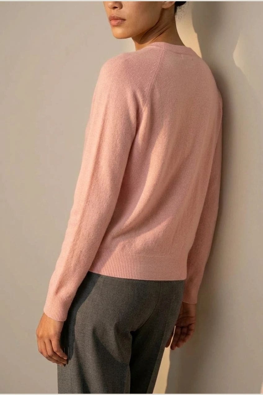 Woman wearing a long sleeve round neck button front cardigan over a grey top with dark slim jeans and ankle boots._3