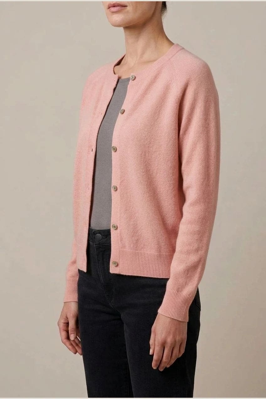 Woman wearing a long sleeve round neck button front cardigan over a grey top with dark slim jeans and ankle boots._4