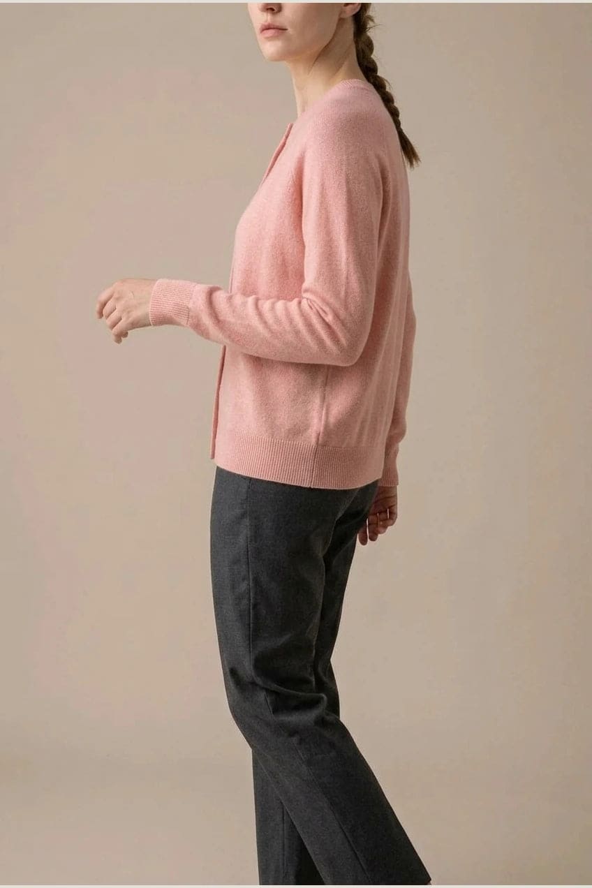Woman wearing a long sleeve round neck button front cardigan over a grey top with dark slim jeans and ankle boots._5