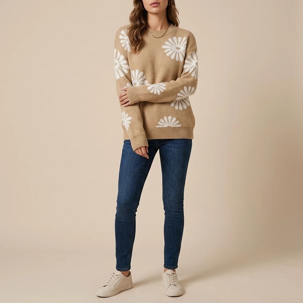 Woman wearing a relaxed crew neck knit jumper with large daisy motifs, blue jeans and low trainers._0