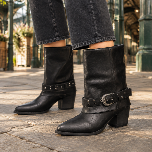 Black Western mid-calf boots with pointed toes, block heels, and studded buckle straps, shown with cropped black jeans.