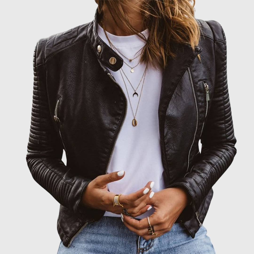 Black faux leather biker jacket styled over a white top and jeans, showing the asymmetric zip front, fitted shape, zip pockets, and quilted sleeves.